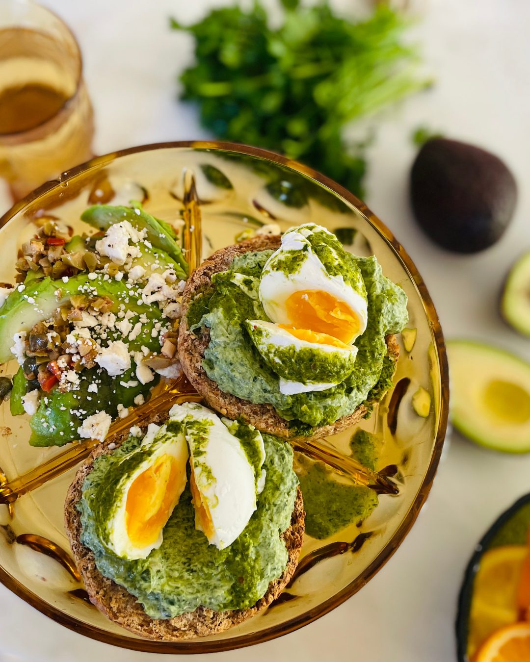 Soft eggs and green sauce on a gold glass plate